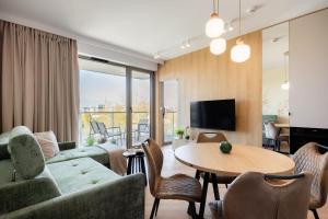 a living room with a couch and a table at Apartament Harmonia Baltic in Sarbinowo