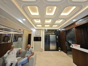 two men sitting on a couch in a lobby at Hotel Kaashika in Varanasi