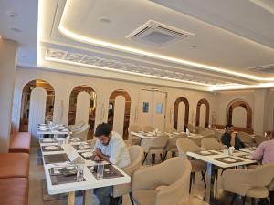 a restaurant with tables and people sitting at them at Hotel Kaashika in Varanasi