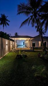 a backyard of a house with a palm tree at Shells By D in Negombo