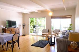 a living room with a table and a couch at Sanctuary Spaces - Wategoes Beach Shack in Byron Bay