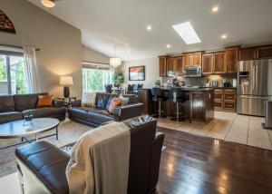 a living room with couches and a kitchen at Modern comfort in Lethbridge