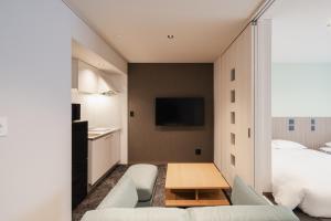 a living room with a couch and a table at Hotel SHUTEC in Kagoshima