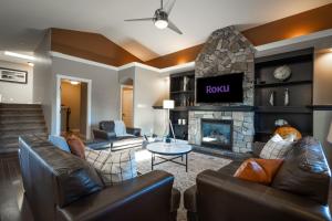 a living room with leather furniture and a fireplace at Modern comfort in Lethbridge