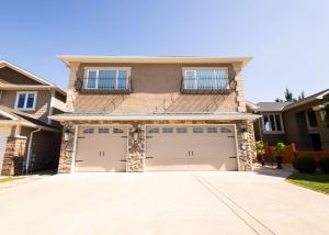 a house with two garage doors in a driveway at Modern comfort in Lethbridge