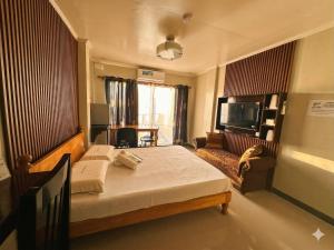a bedroom with a large bed and a television at Marjhun's Apartelle in Jagna +45 photos
