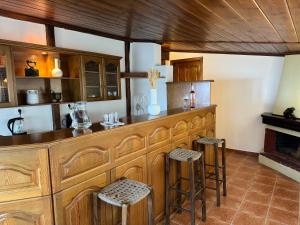 a kitchen with a counter and stools in a room at Poarta 1 in Portaria +8 photos