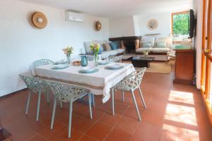 a living room with a table and chairs and a couch at Villa Fornaci - Marina di Campo in Marina di Campo