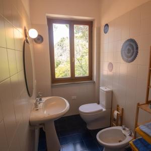 a bathroom with a sink and a toilet and a window at Villa Fornaci - Marina di Campo in Marina di Campo +54 photos