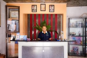 a man sitting at a counter in a room at Hotel Griya Wijaya Ambarawa in Ambarawa