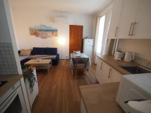 a kitchen and living room with a couch and a table at Le Picaflor YourHostHelper in Hyères