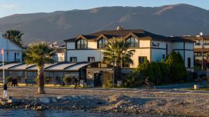a building with palm trees and mountains in the background at Room 23 Hotel in Akçay