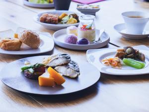 a wooden table with plates of food on it at Furano Hotel 富良野ホテル in Furano