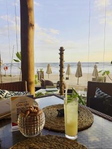 a table with a glass of juice on the beach at Taavetti in Galle