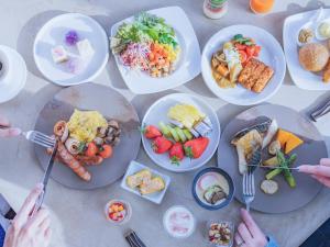 a table full of plates of food with people holding forks at Furano Hotel 富良野ホテル in Furano +75 photos