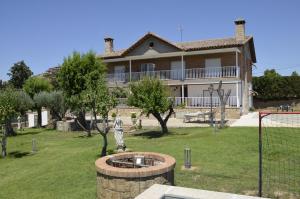 a house with a fountain in front of a yard at Sueña Toledo- Apartamentos turisticos con piscina in Toledo