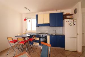 a kitchen with blue cabinets and a table and chairs at Ayra's House Otranto in Otranto
