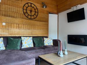 a living room with a couch and a clock on the wall at Le Petit Paradis in Honfleur