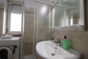 a bathroom with a sink and a washing machine at Ayra's House Otranto in Otranto