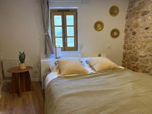 a bedroom with a bed and a window and a table at Le Petit Coin in Saintes