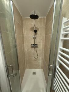 a bathroom with a shower with a glass door at Le Petit Coin in Saintes