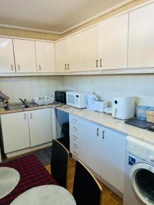 a kitchen with white cabinets and a washing machine at TurisMar Vila do Conde in Macieiro da Maia