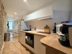 a kitchen with white cabinets and a counter top at Le Petit Coin in Saintes +22 photos
