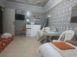 a living room with a table and chairs in a room at Ahmed house in Agadir