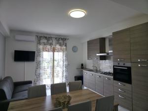 a kitchen and dining room with a table and a couch at Moonlight Apartment in Schisò +6 photos