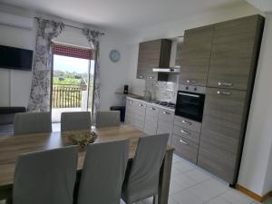 a kitchen with a table and chairs and a dining room at Moonlight Apartment in Schisò