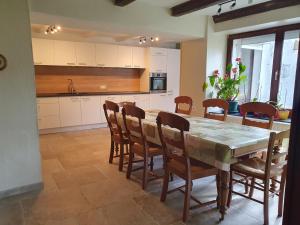 a kitchen with a dining room table and chairs at Sur la Rive Vierre in Suxy