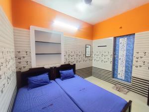 a bedroom with a blue bed and a window at Siva Lodge in Rāmeswaram