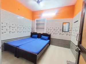 a bedroom with a blue bed in a room at Siva Lodge in Rāmeswaram +4 photos