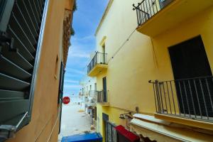 an alley with yellow buildings and a stop sign at Dimora Cariddi al Centro Storico in Otranto
