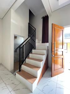 a staircase in a house with a wooden door at D & R House Syariah in Jagalan