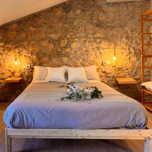 a bed in a room with a stone wall at Villa Jimena in Periana