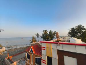 a building with a colorful roof next to the beach at EESHA Beach View Stay - Near Temple and Beach in Rāmeswaram