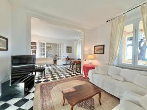 a living room with a white couch and a tv at VILLA NORMA in Levanto