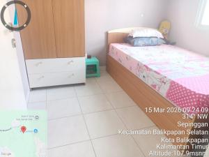 a small bedroom with a bed and a cabinet at Villa IDR Grandcity in Balikpapan