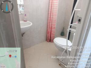 a bathroom with a toilet and a sink at Villa IDR Grandcity in Balikpapan