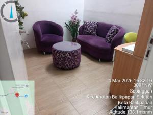 a room with two purple chairs and a table at Villa IDR Grandcity in Balikpapan