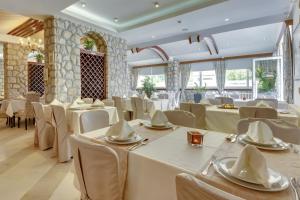 a banquet hall with white tables and chairs at Sutomore Akapulco Hotel in Sutomore