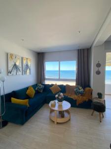 a living room with a blue couch and a table at Estrella de Martil in Martil