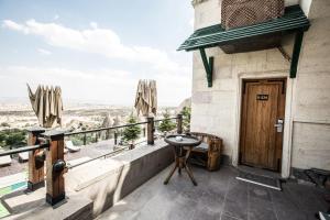 a balcony with a wooden door and a table at CCR Cappadocia Cave Resort &Spa in Eskiömerler
