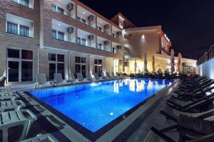 a swimming pool in front of a hotel at night at Sutomore Akapulco Hotel in Sutomore