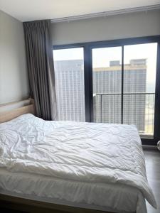 a bedroom with a white bed and a large window at ริเวอร์วิวแม่น้ำเจ้าพระยา62ชั้น in Ban Sai Ma
