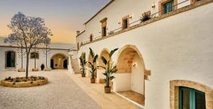 a building with a courtyard with potted plants on the side at Bambarone L'Agriturismo in Fasano