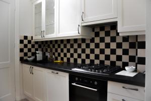 a kitchen with a black and white checkered wall at Hotel Nieuwe Markt in Deventer +3 photos