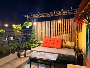 an orange pillow on a bed on a patio at Lynk Stay Hoian in Hoi An