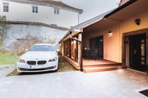 a white car parked on a porch next to a house at Residence Legio XIII Gemina in Ptuj